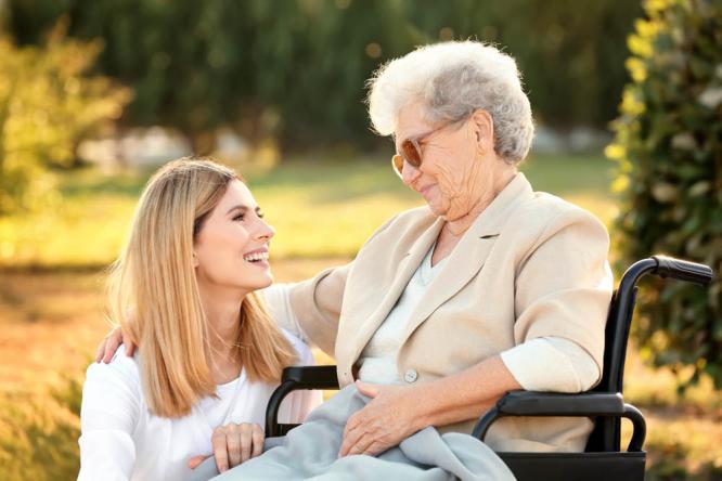 A home caregiver talking warmly with an older adult